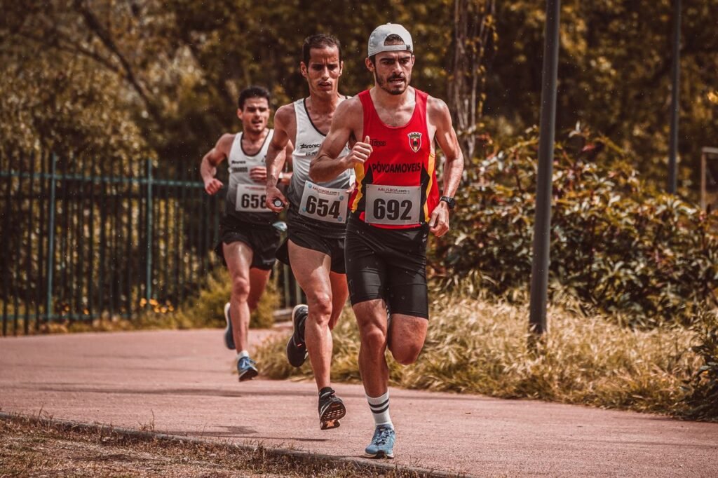 Three male runners compete in a marathon event, showcasing endurance and athleticism outdoors.